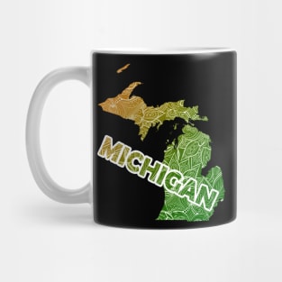 Colorful mandala art map of Michigan with text in green and orange Mug